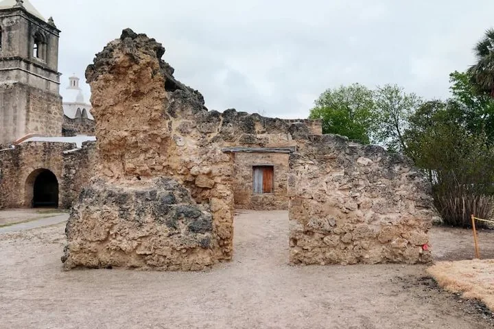 Ruins of a stone mission building with a wooden window shutter