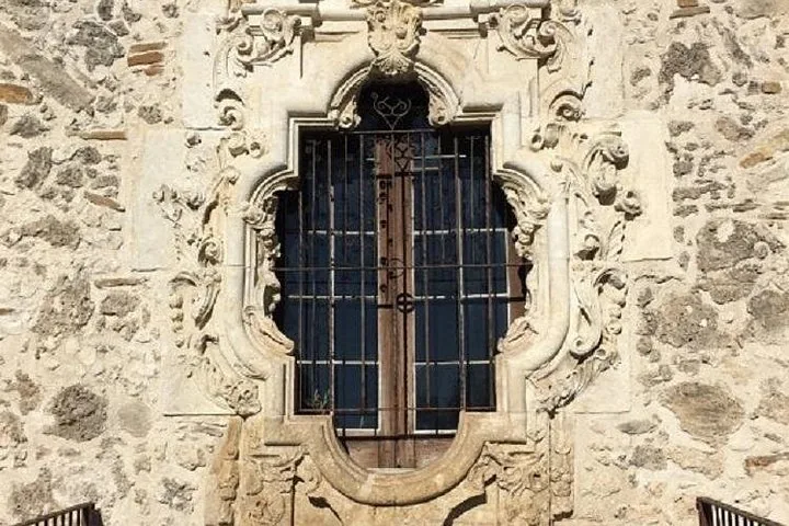 Close-up of the ornate carved stone window at Mission San Jose